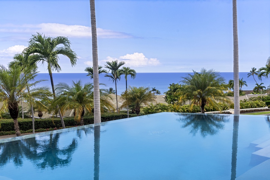 Infinity pool reflects ocean blues and swaying palms for the ultimate Big Island experience.