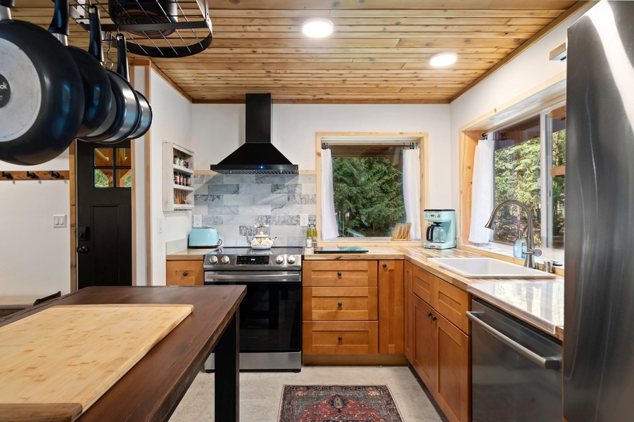 A fully stocked kitchen with butcher block countertops and copper accents offers everything you need for home-cooked meals.