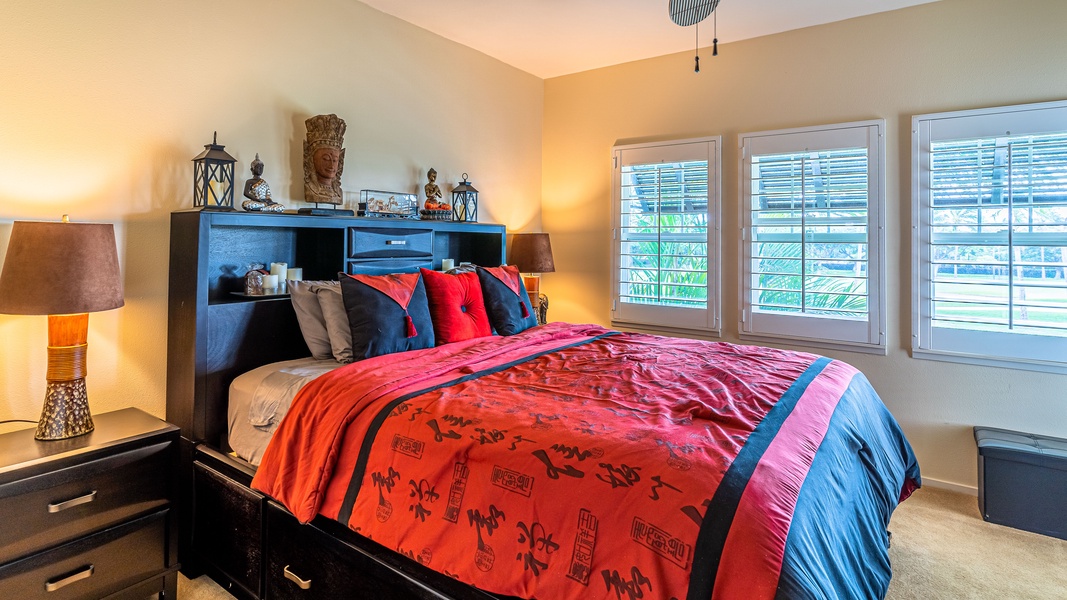 The primary guest bedroom with a TV and ceiling fan.