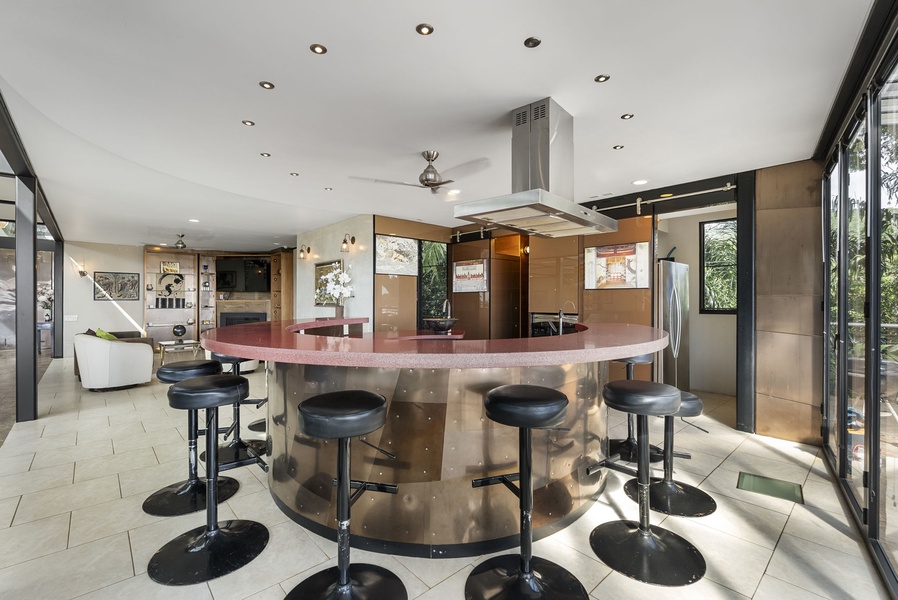 A striking ruby-red kitchen island with seating for twelve, ideal for entertaining.