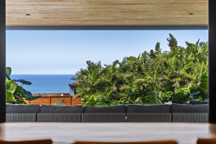 Sweeping ocean views framed by vibrant tropical plants and a modern patio design.