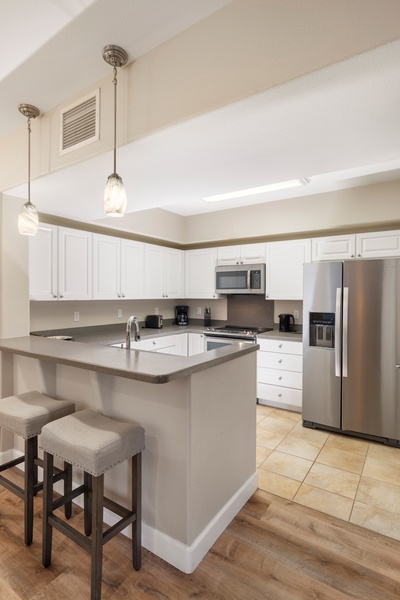 Your fully equipped kitchen awaits with modern appliances, granite countertops, and breakfast bar seating for casual dining.