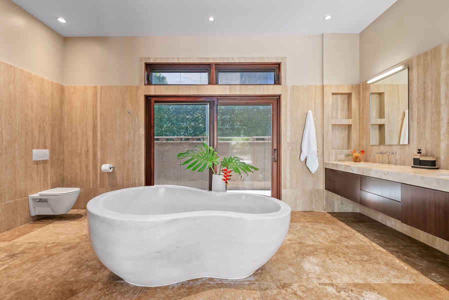 A large soaking tub awaits in the spa-like ensuite bath after a day of exploration.