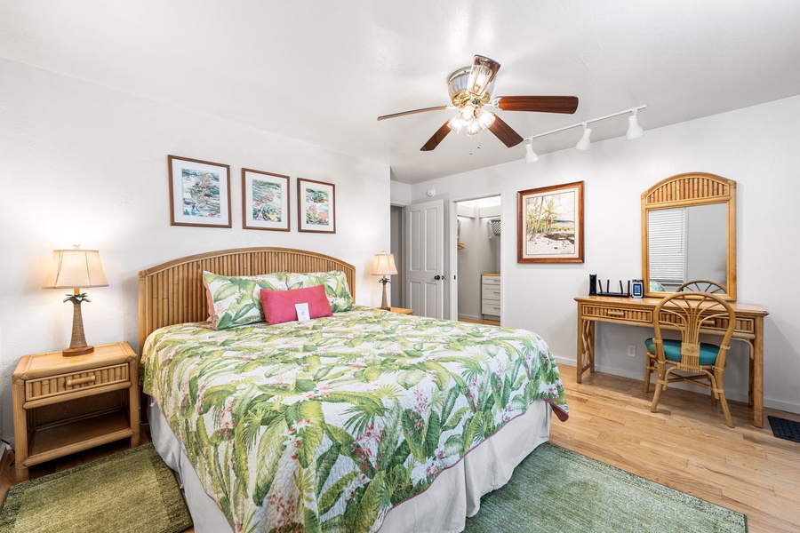 Your tropical paradise bedroom awaits with bamboo furnishings, vibrant botanical bedding, and a dedicated workspace for ultimate comfort.