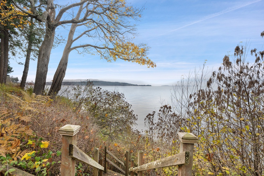Follow the rustic steps to the tidal shoreline—your private path to peaceful beach strolls and salty sea air.
