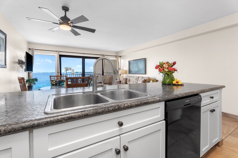 Ocean view reflections from the kitchen—granite counters, bar seating, and tropical breezes just steps away.