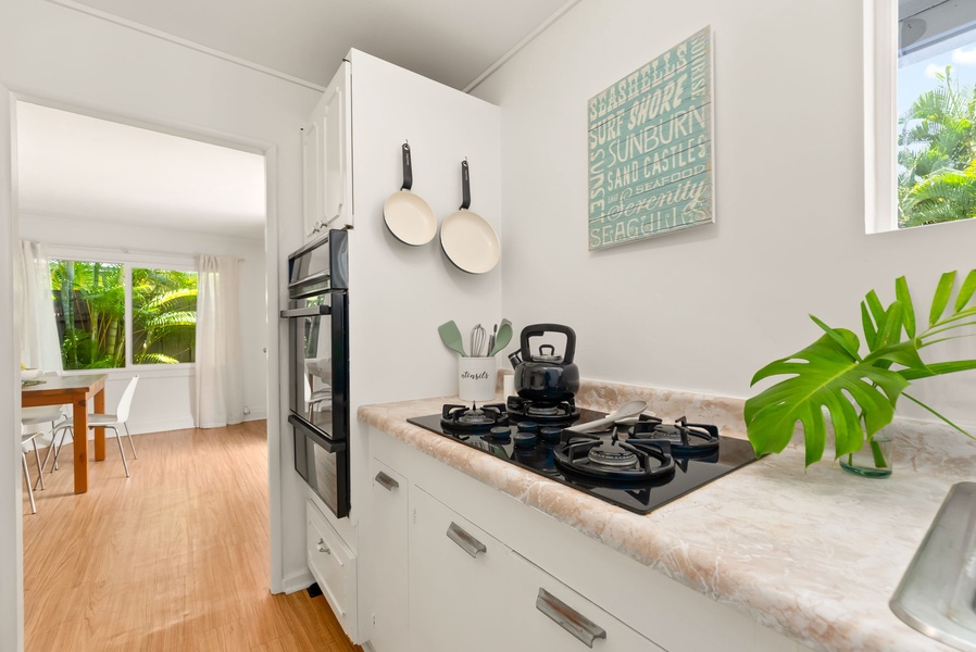 The fully-equipped kitchen with modern appliances and charming coastal décor. Cook your favorite meals on the gas stove while enjoying bright, tropical views through every window.