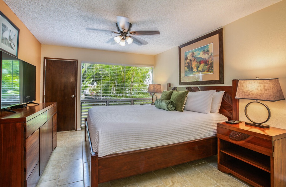 The primary suite offers a plush queen bed with access to the lanai
