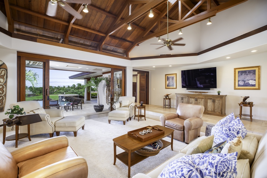 Unwind in your spacious living room featuring soaring wood ceilings and tropical elegance throughout.