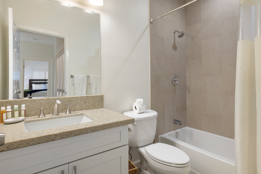 Second guest bathroom includes a tub/shower combo, large vanity, and elegant finishes.