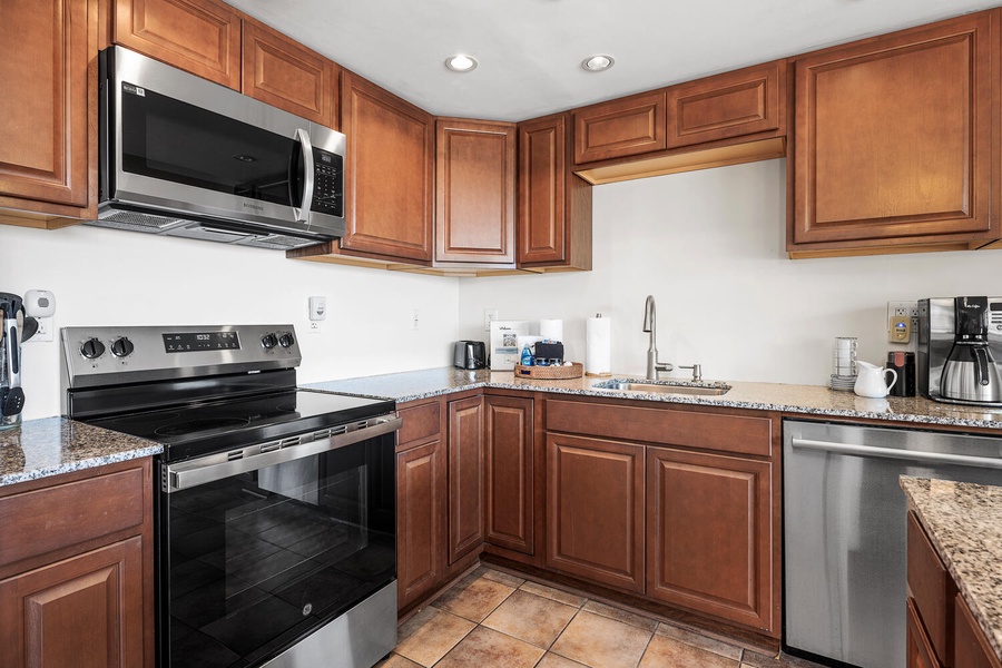 Fully equipped kitchen features warm wood cabinets, granite countertops, and stainless steel appliances for memorable home-cooked meals.