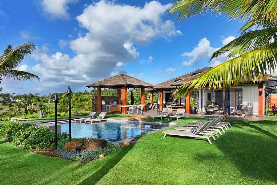 Immerse yourself in luxury with this pool and spa combo, featuring lounging areas and tropical landscaping.