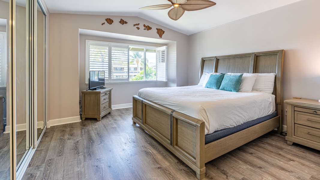 The primary guest bedroom with a king size bed, dresser and television.