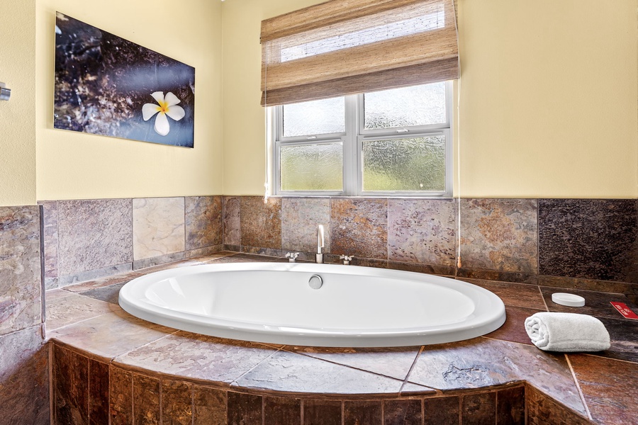 Luxurious bathroom with a deep soaking tub surrounded by elegant tile, perfect for unwinding.