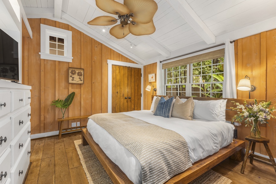 Downstairs guest bedroom in main house has a king-sized bed and ceiling fan.