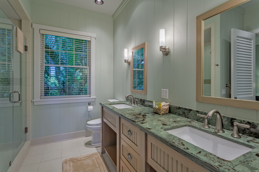 Bathroom 2 with Granite Countertops, Double Sink Vanity, Spacious Tiled Shower w/ Two Shower Heads. Two Doors to Bedroom 2 and Hallway.