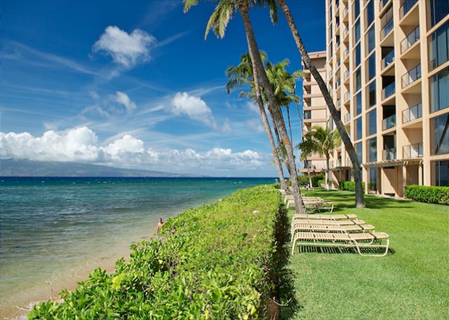 Oceanfront property with sunbathing loungers, perfect for relaxing by the beach.