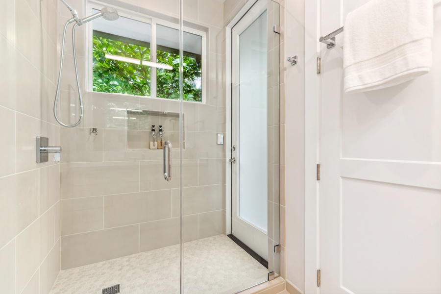 Modern shower with glass doors and high-end fixtures, creating a spa-like ambiance.