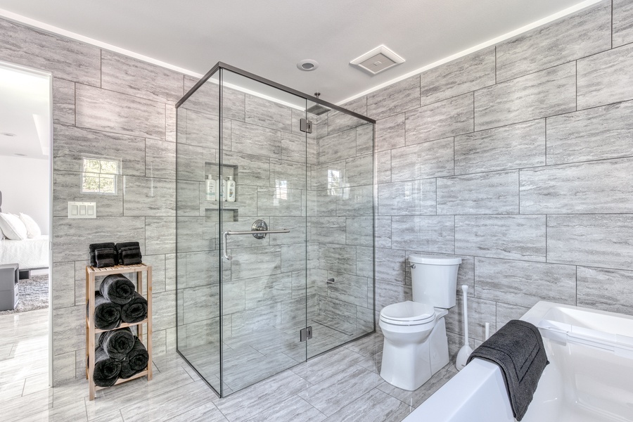 Modern glass enclosed shower in primary bathroom