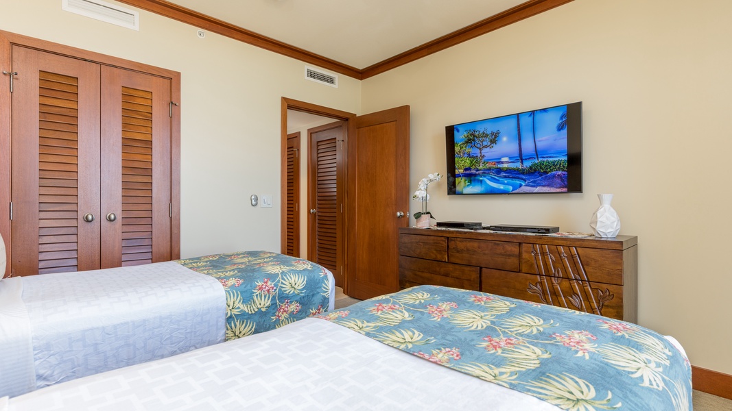 The second guest bedroom with a TV and bright designs.