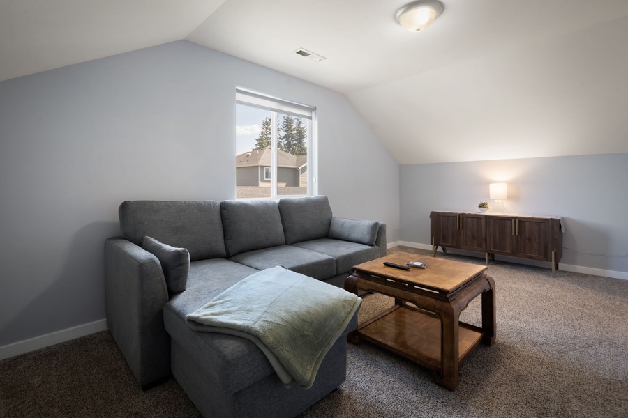 Gather in the upstairs lounge, offering an additional space perfect for movie nights, reading, or quiet afternoons.