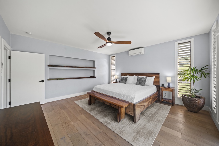 Bright and airy primary bedroom featuring a king-sized bed and stylish shelving.