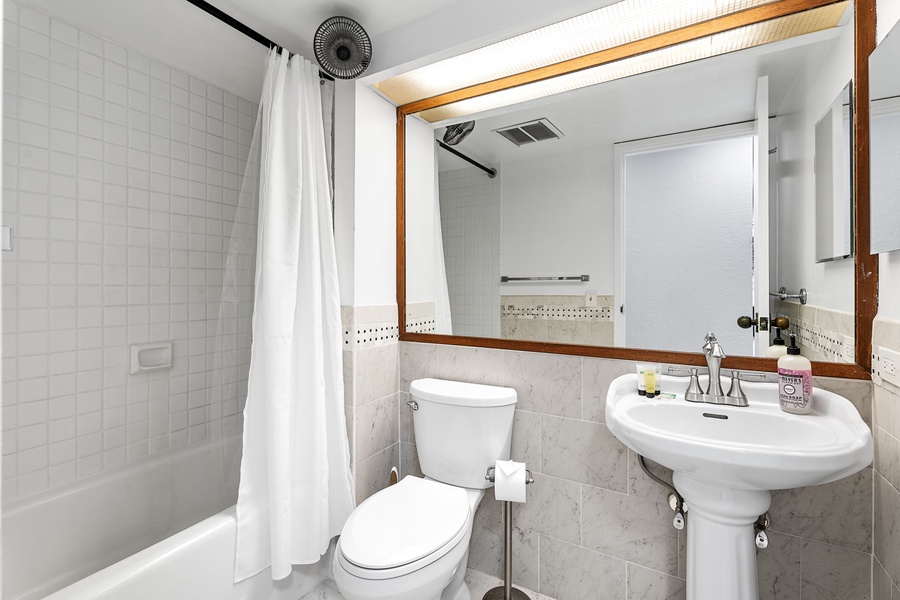 Compact guest bathroom featuring a pedestal sink and clean design.