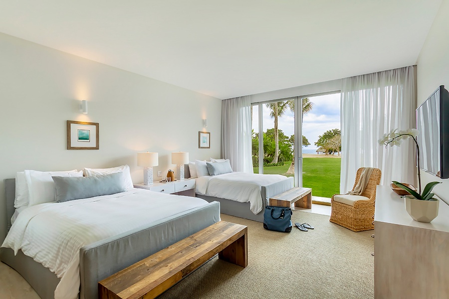 The guest bedroom offers two queen beds and private patio.