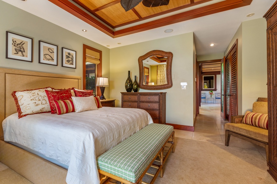 This elegant guest bedroom features a king bed, tropical accents, and a private ensuite bath for a restful retreat.