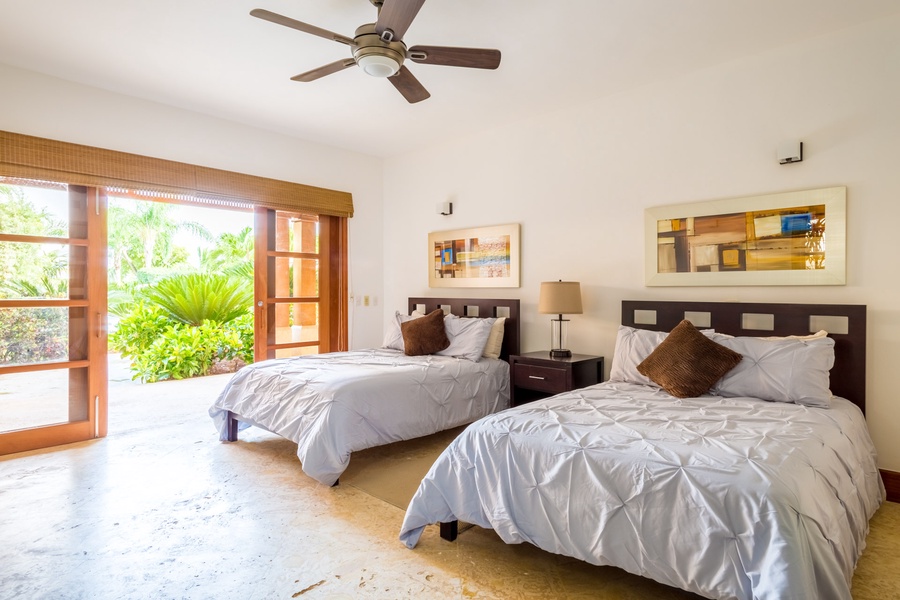 Inviting guest bedroom with twin beds and direct access to the garden.