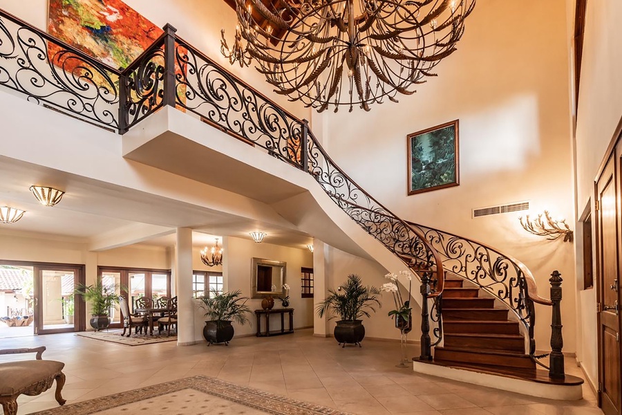 The grand foyer featuring a staircase and stunning chandelier.