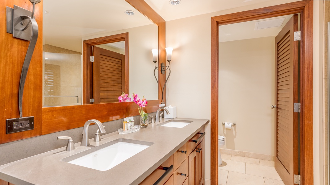 The primary guest bathroom featuring a double vanity and ample lighting.