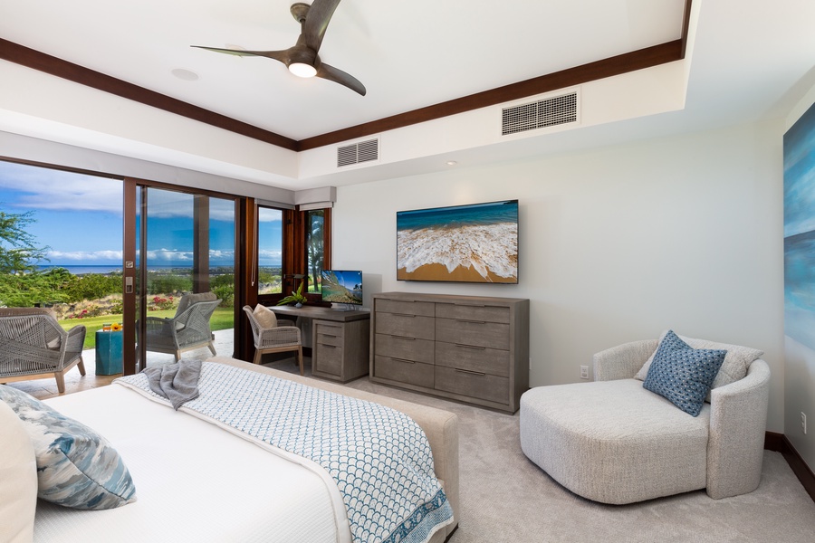Primary suite bedroom with views of the private ocean view lanai, work space and 55’’ flat screen TV