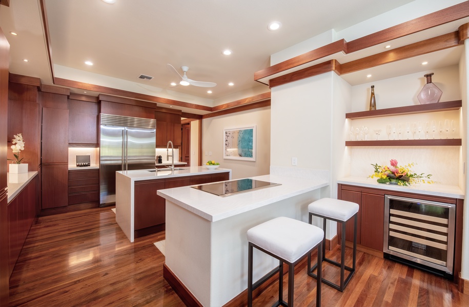 Contemporary kitchen with dual ovens, high-end appliances, wine fridge and bar area.