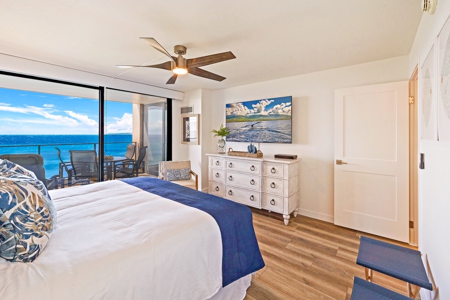 The primary bedroom at Mahana 1118 features lanai access and breathtaking ocean views.