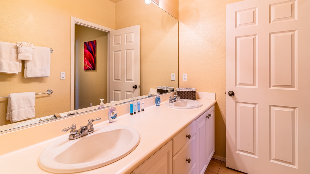 The second guest bathroom located upstairs with a double vanity.