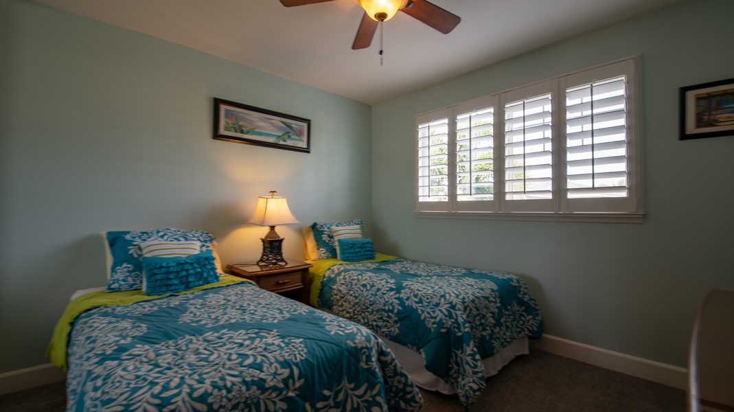 The third guest bedroom with twin beds and natural lighting.