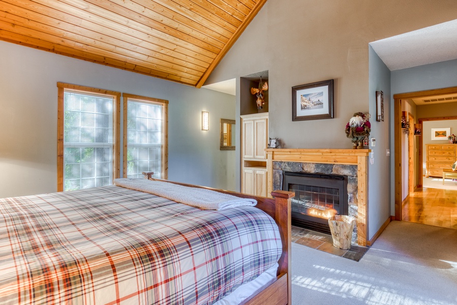 Snuggle up in the cozy guest bedroom with a fireside bed, access to the deck, and accentuated with rustic charm.
