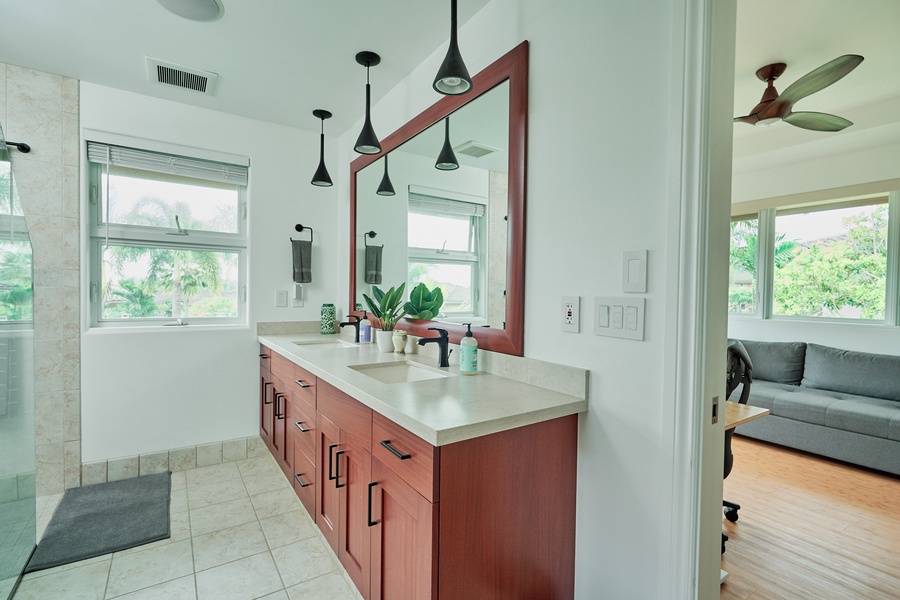 Refresh in your spacious bathroom with dual vanities, modern fixtures, and lush garden views through every window.