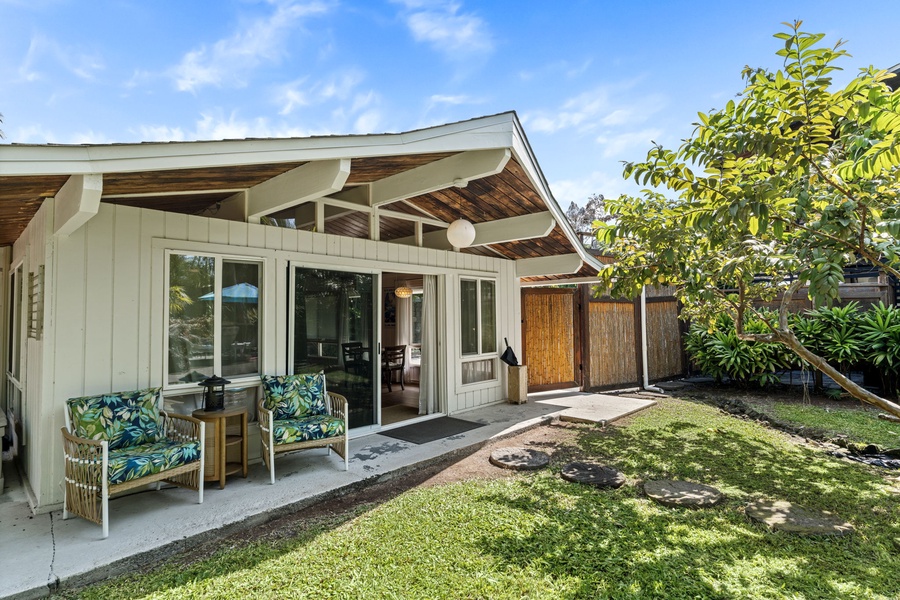 Relax on your private patio with tropical-print seating, surrounded by lush gardens and modern comfort in this charming retreat.