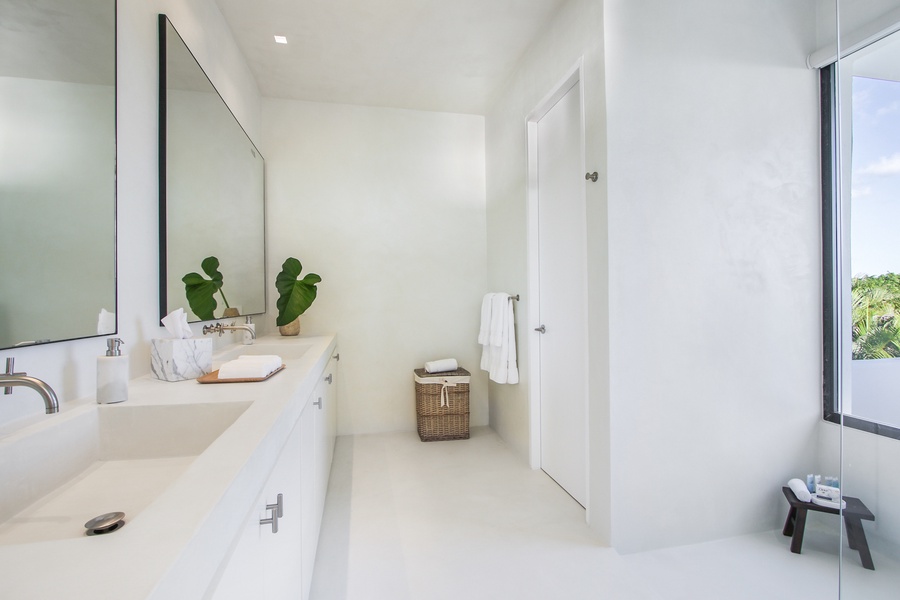 Refresh in the bright ensuite bathroom with a large mirror and simple design.