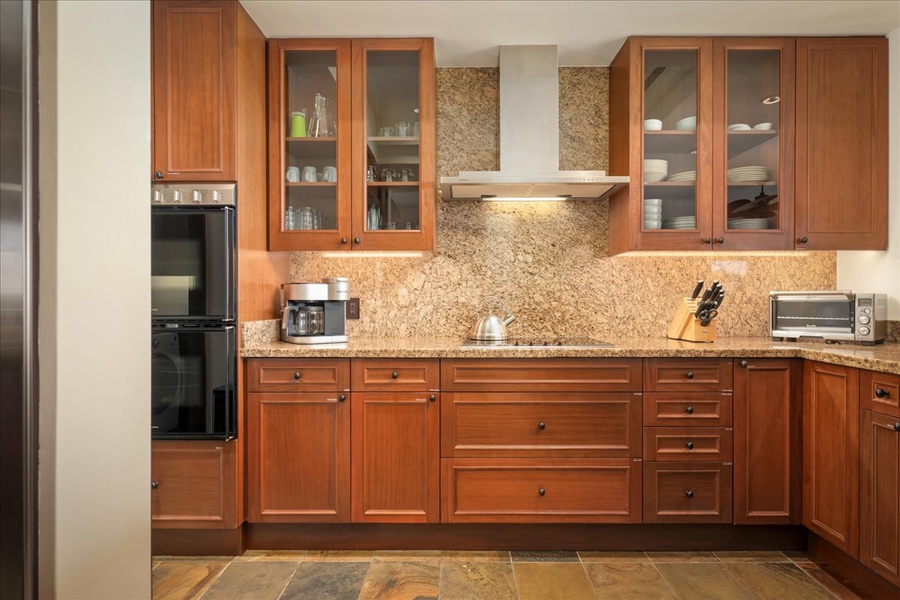 Gleaming and spacious kitchen with granite countertops and travertine flooring.