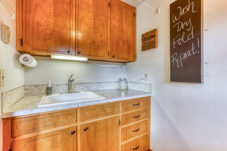 Laundry room is welcoming and includes a washer, dryer and large sink