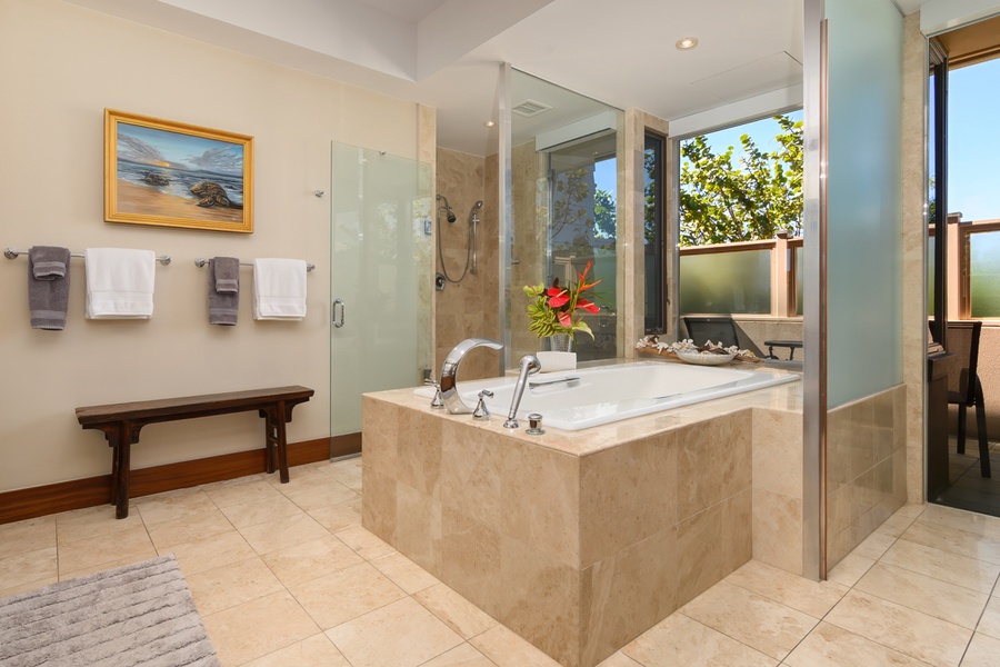 Unwind in your spa-like bathroom with a luxurious soaking tub and rainfall shower, where tropical flowers and garden views create your private retreat.