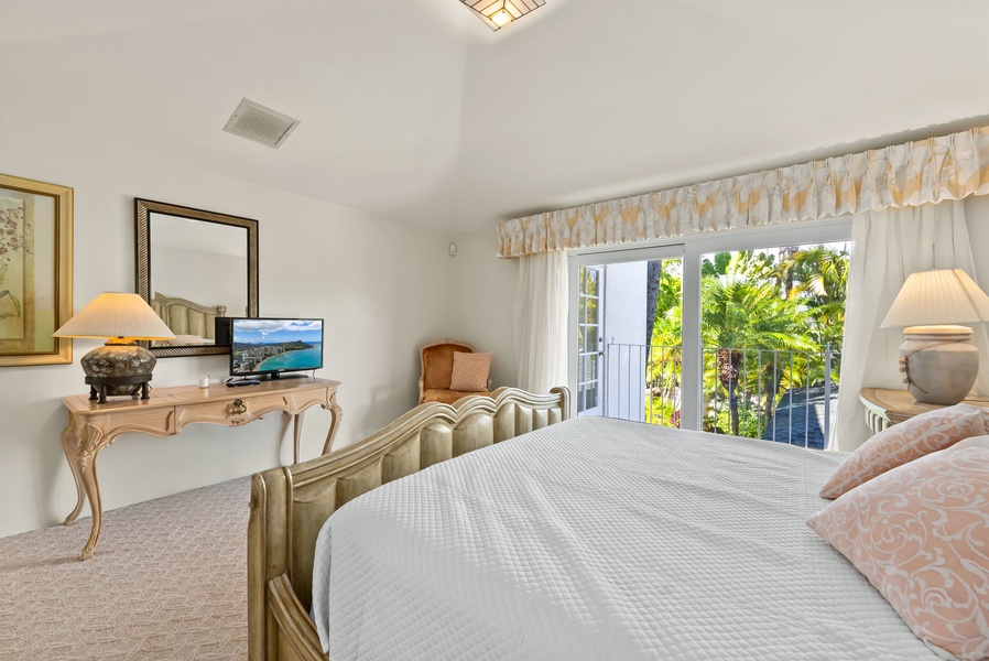 Spacious guest suite with access to a balcony, letting in natural light and offering beautiful outdoor views.