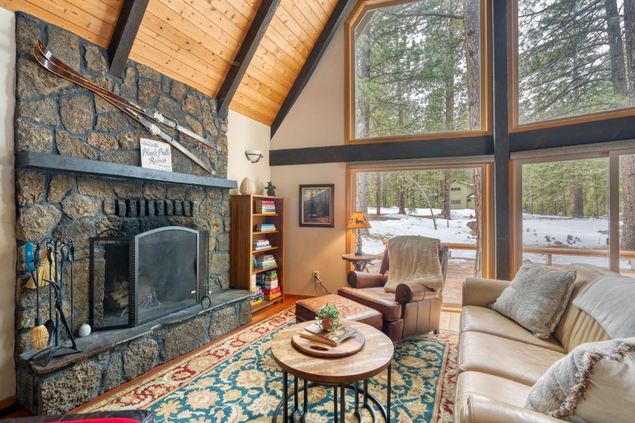 The home features large windows to enjoy the outdoor views while reading a book by the wood-burning fireplace