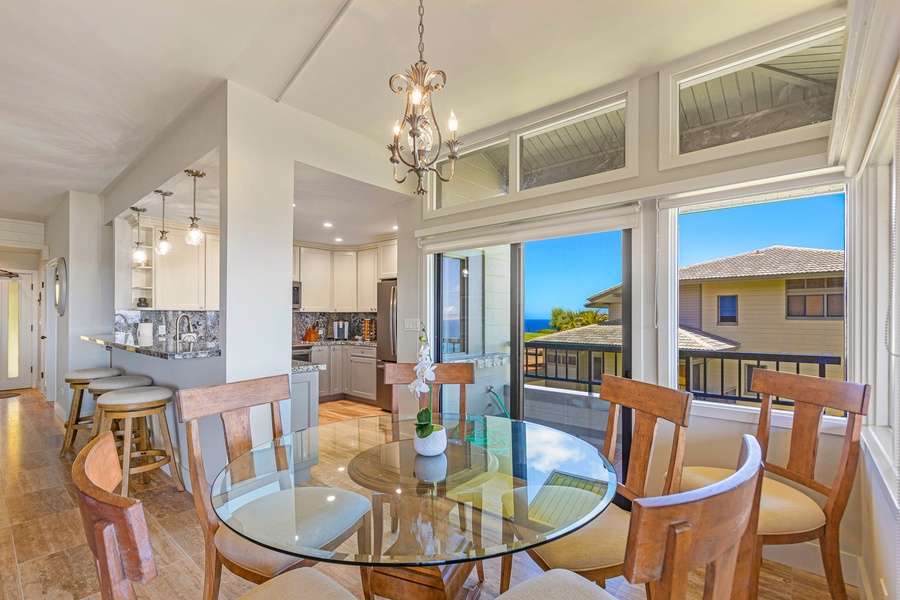 The bright and airy dining area is accented by a chic chandelier and large windows that flood the space with natural light