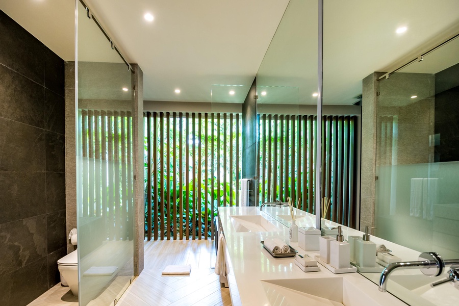Sophisticated ensuite bathroom with a dual sink vanity and glass-enclosed shower.