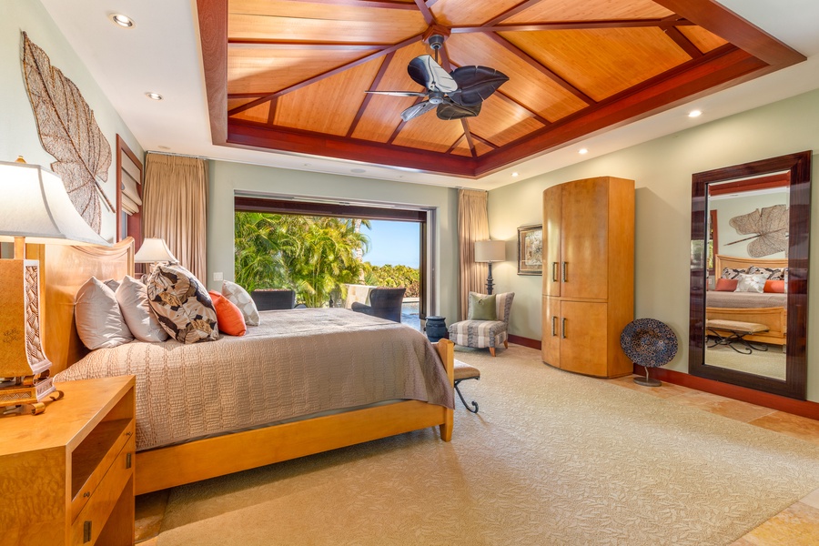 Enjoy restful nights in a spacious primary suite with elegant ceiling details and sliding glass doors to the lanai.