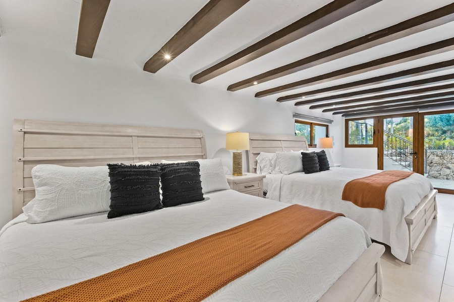 Clean and cozy guest bedroom with two cozy beds and access to the garden.